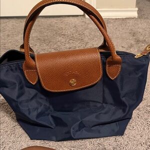 Longchamp small navy tote with holes in the corners for a crossbody strap